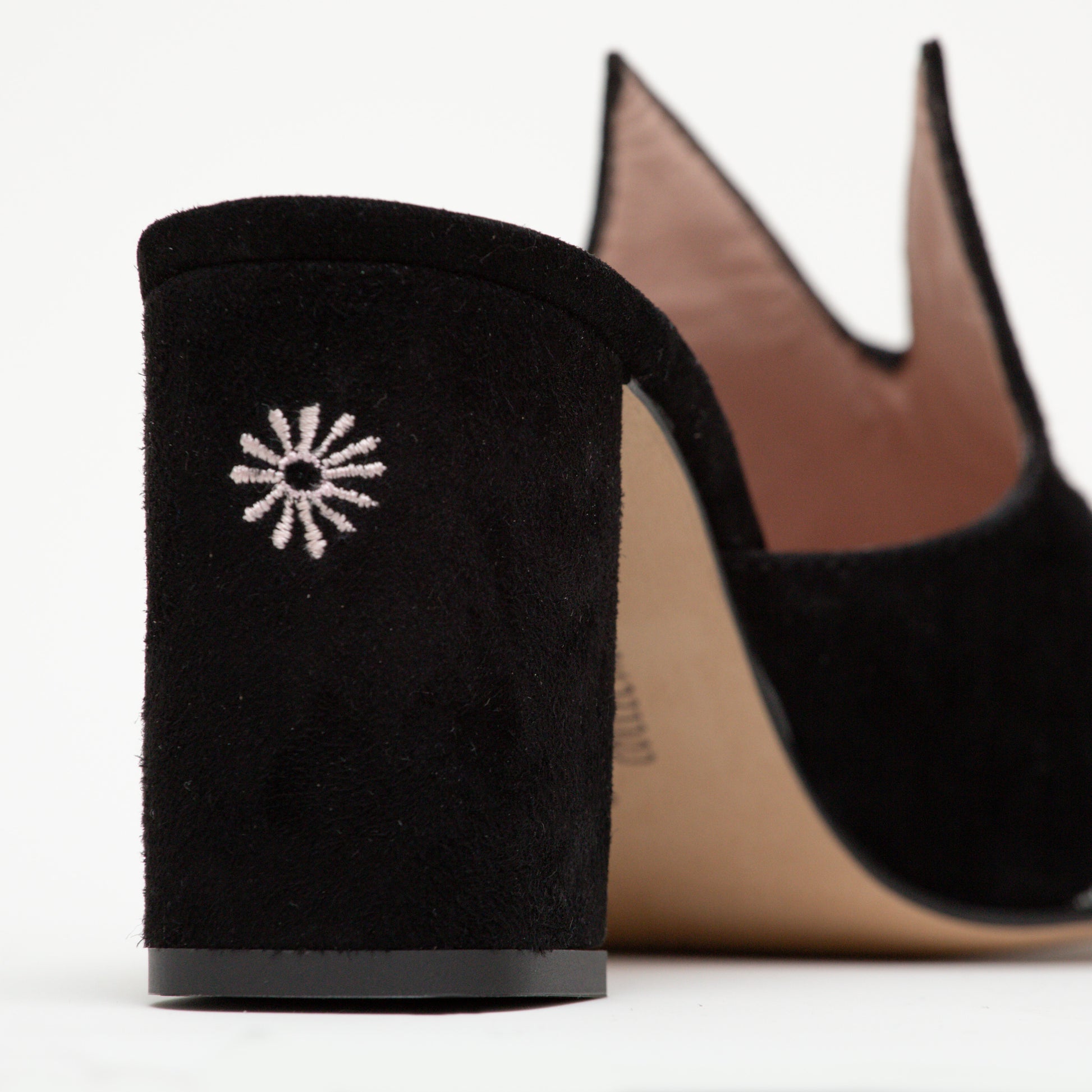 The back of the Sylvie mule has an embroidered butt design on the heel. The iconic cat ears can be seen behind.