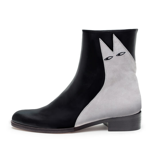 A black leather boot with a low heel featuring a simple light grey suede cat design called Etta