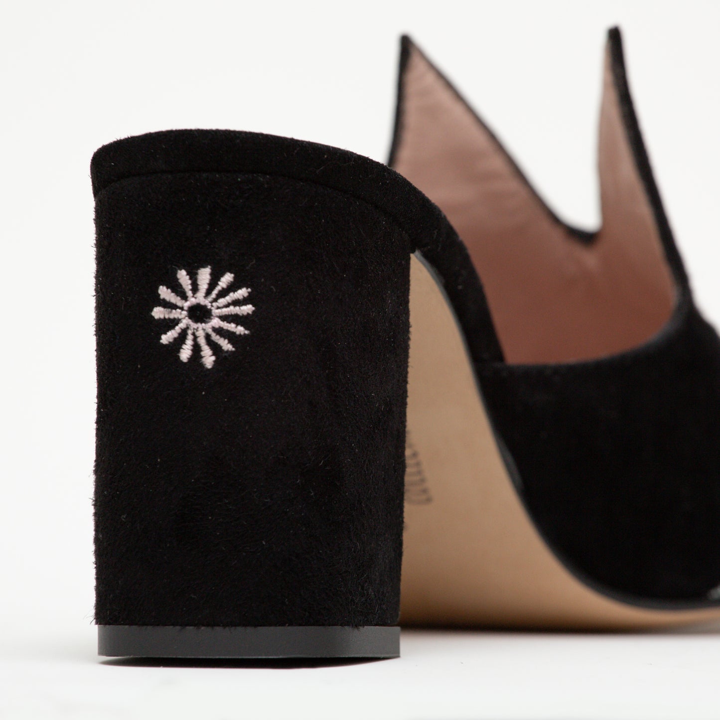 The back of the Sylvie mule has an embroidered butt design on the heel. The iconic cat ears can be seen behind.